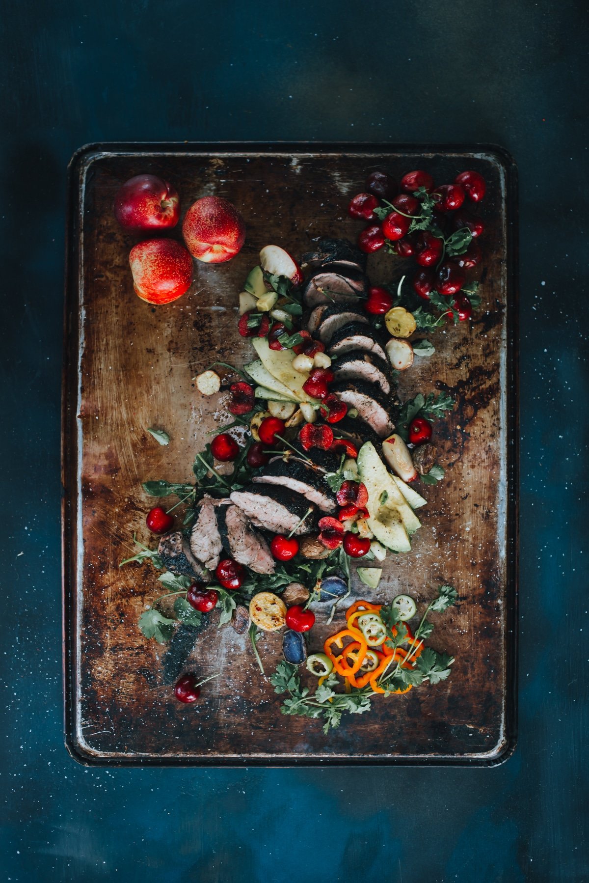 a truffle rubbed grilled pork tenderloin sliced thin with bright stone fruit salsa and garnish