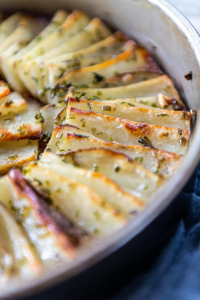 Perfectly browned edges of thin slices potatoes rolled in duck fat and baked 