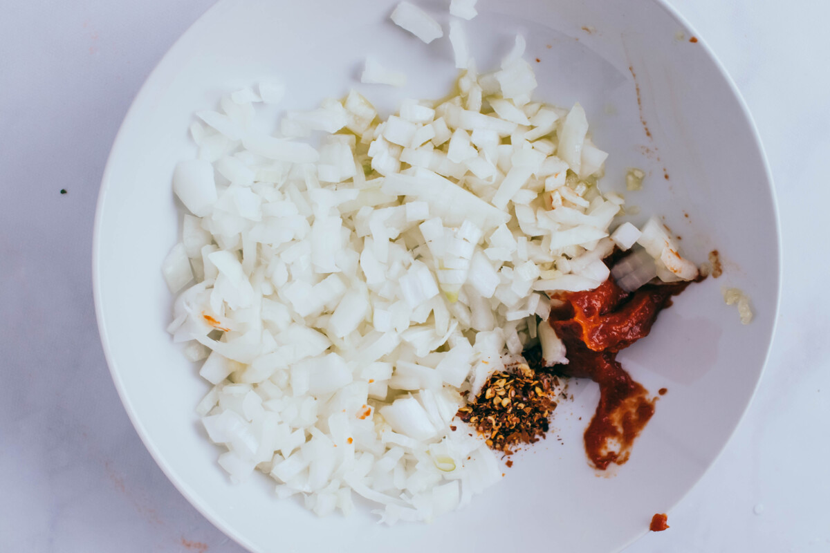 onion, spices, and tomato paste in bowl