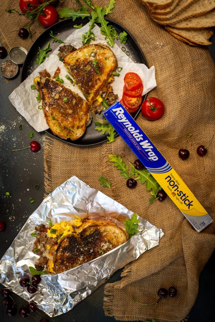 grilled cheese sandwiches on table with reynolds wrap foil, tomatoes and other ingredients