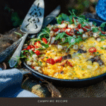 Skillet frittata loaded with meats and cheese and topped with fresh arugula and tomatoes