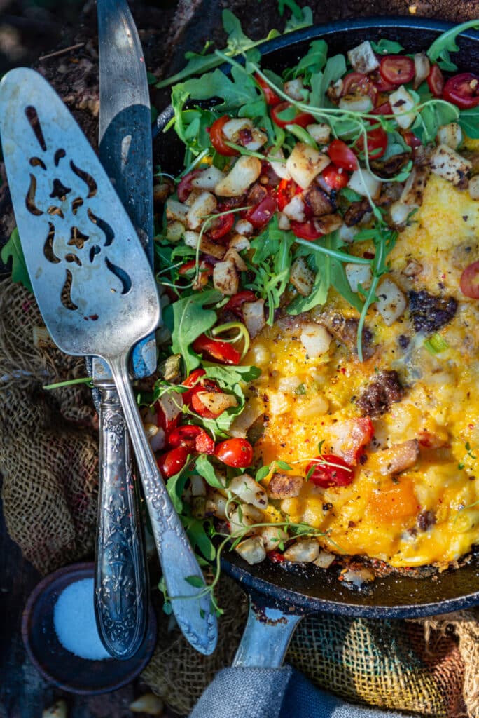 Overhead shot of this colorful skillet with serving utensils on the side. 