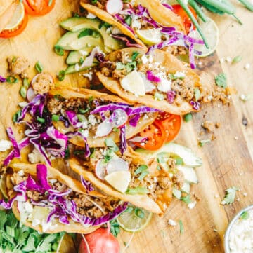 Quick and easy ground pork tacos in homemade fried shells with all the toppings on a board