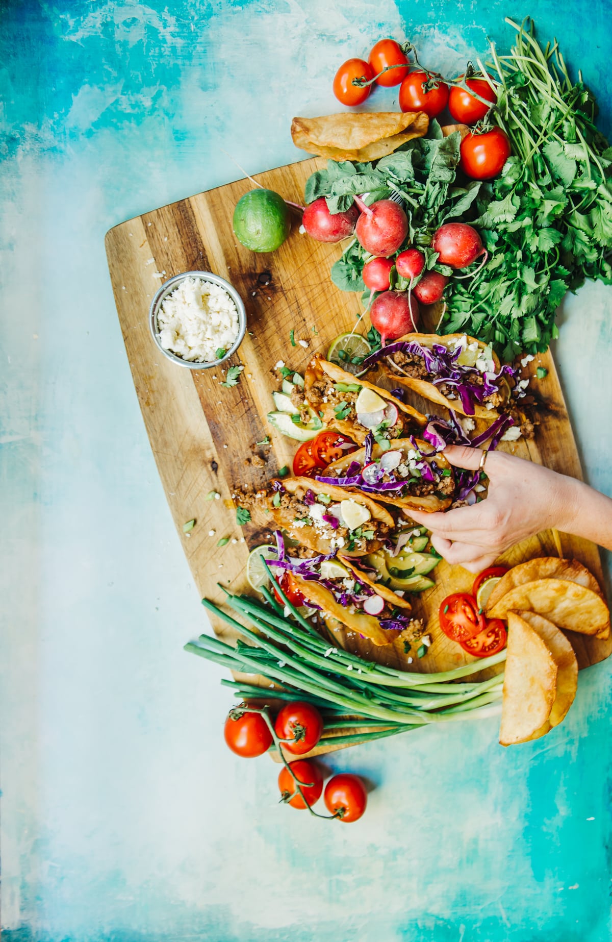 Hand grabbing taco from the tray. 