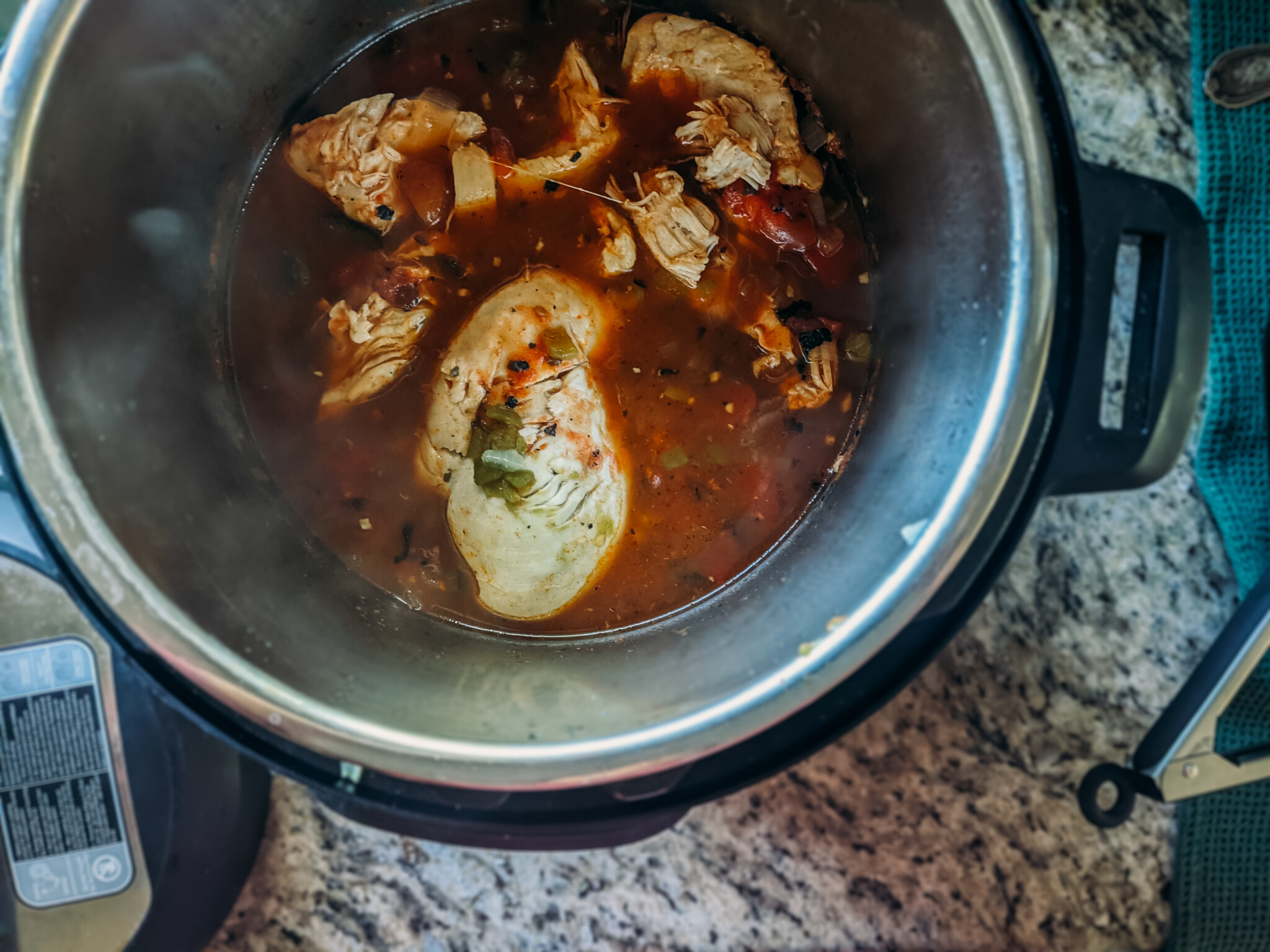 Chicken in an instant pot with liquid, chipotle peppers and more. 
