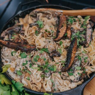 Cast iron pan filled with creamy meatball stroganoff and portabella mushrooms
