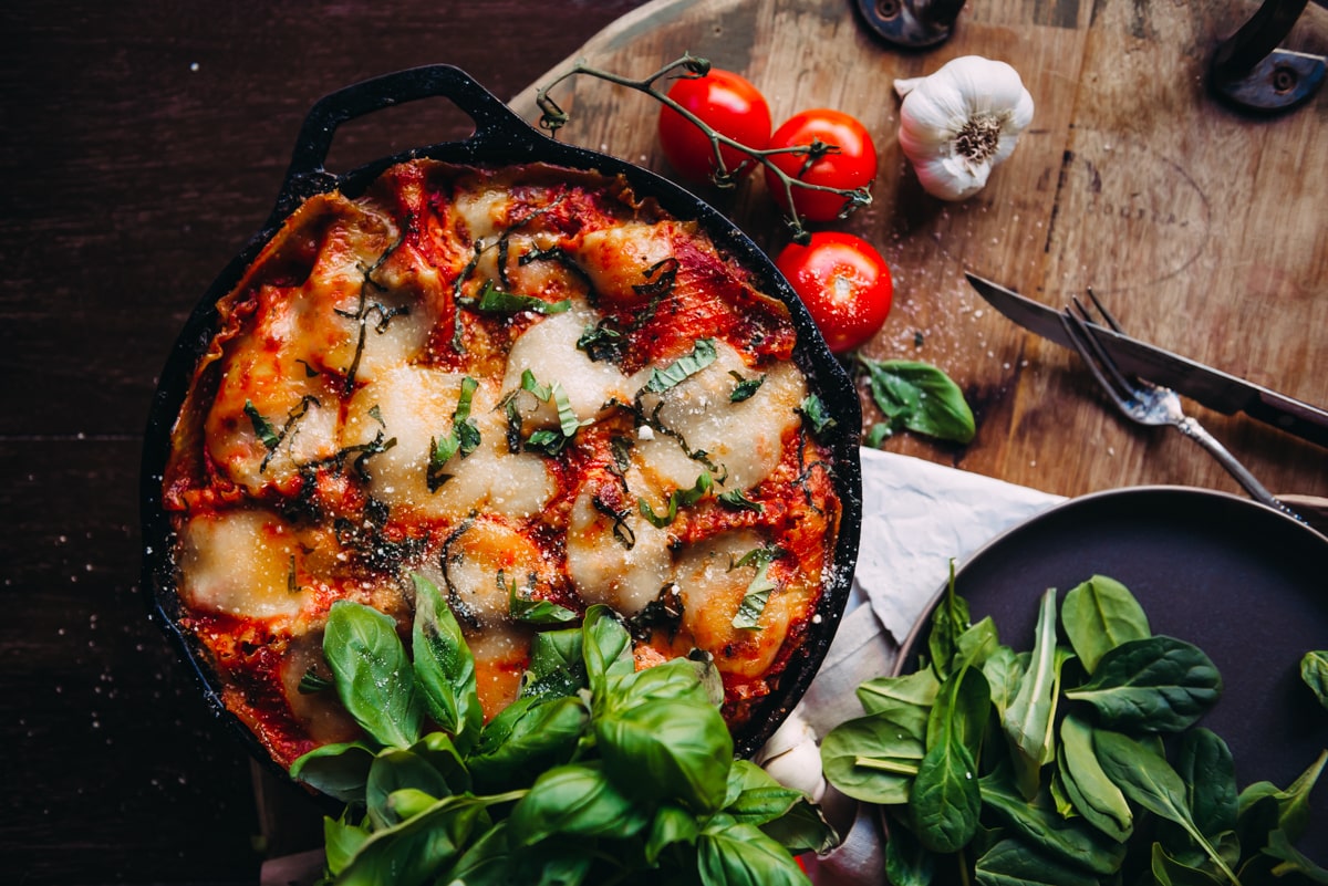 Cheesy Skillet Lasagna in a Table with Garlic, Cherry Tomato, Basil and Spinach