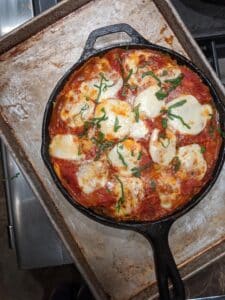 skillet lasagna fresh from oven in cast iron on a baking sheet