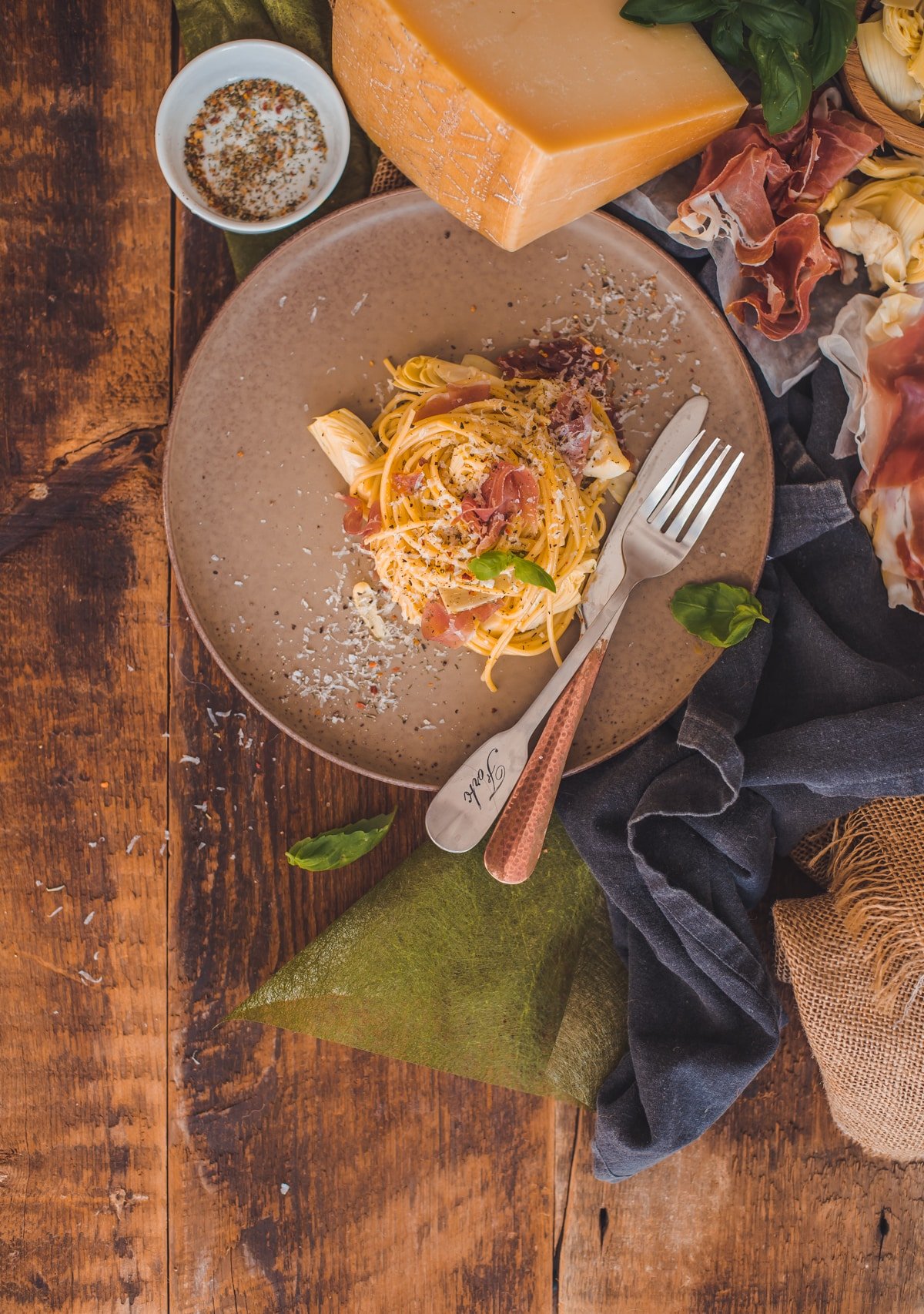 Classic Carbonara in a Plate along with Prosciutto and Grana Padano Cheese.