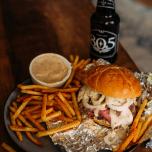 pit beef sandwich on plate with fries and a beer