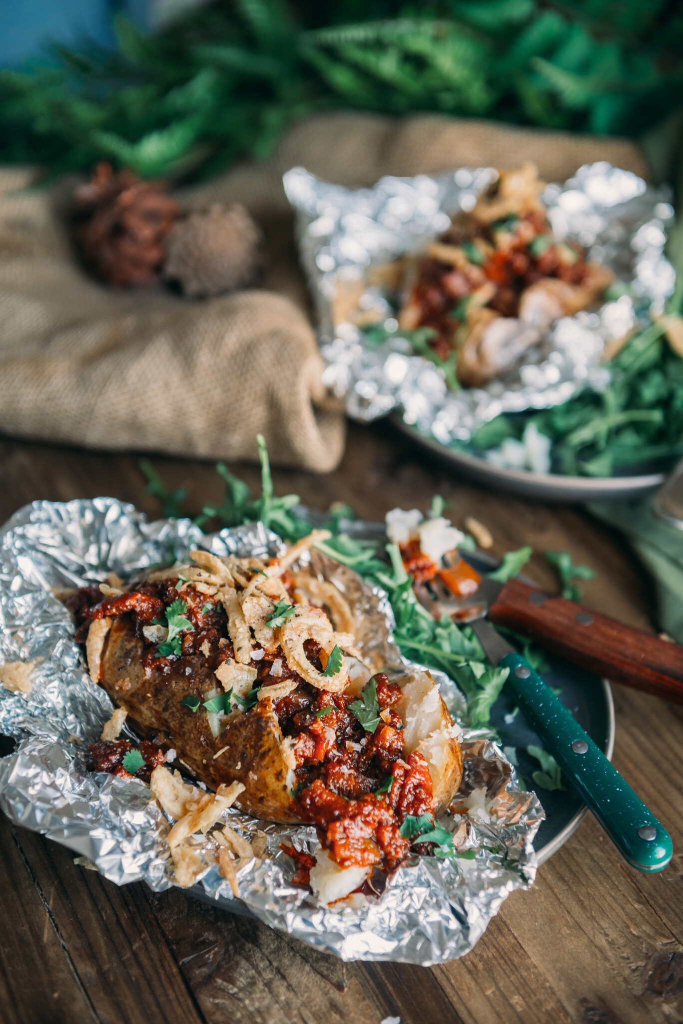 Baked potato opened in foil and topped with sloppy joe mix, crispy onions and garnished with minced parsley. 