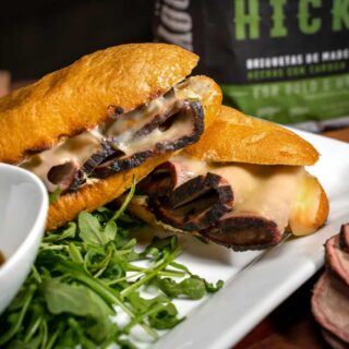 A sandwich is on a plate next to a bag of meat, exploring umami flavors.