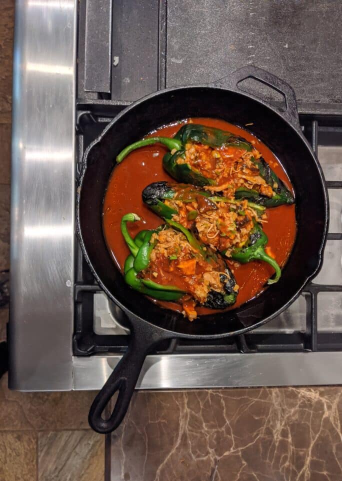 cast iron skillet with chicken tinga stuffed poblanos - recipe steps