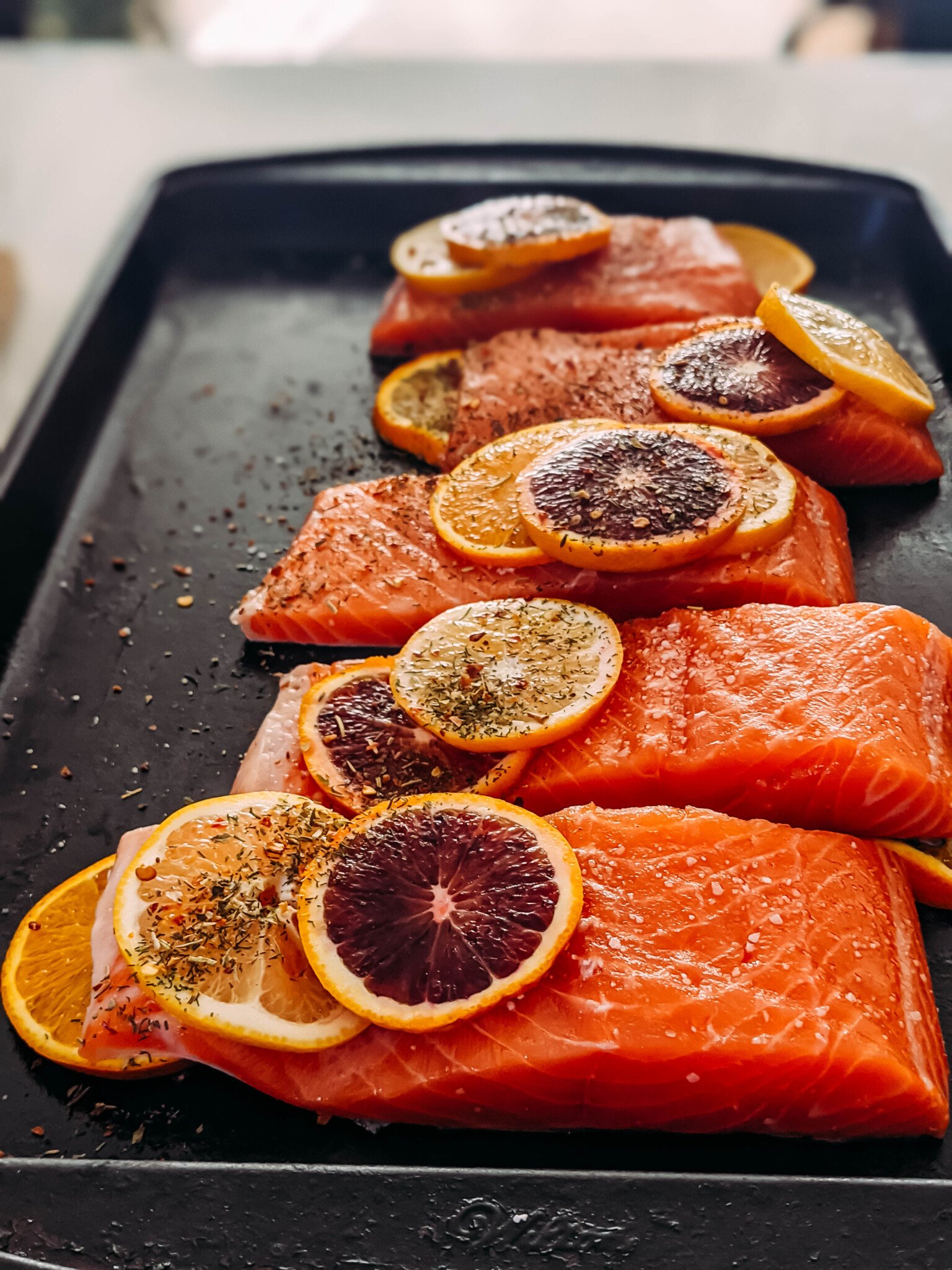 raw salmon assembled on a baking sheet to be cooked with citrus