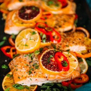 citrus baked salmon topped with sliced sweet peppers and herbs