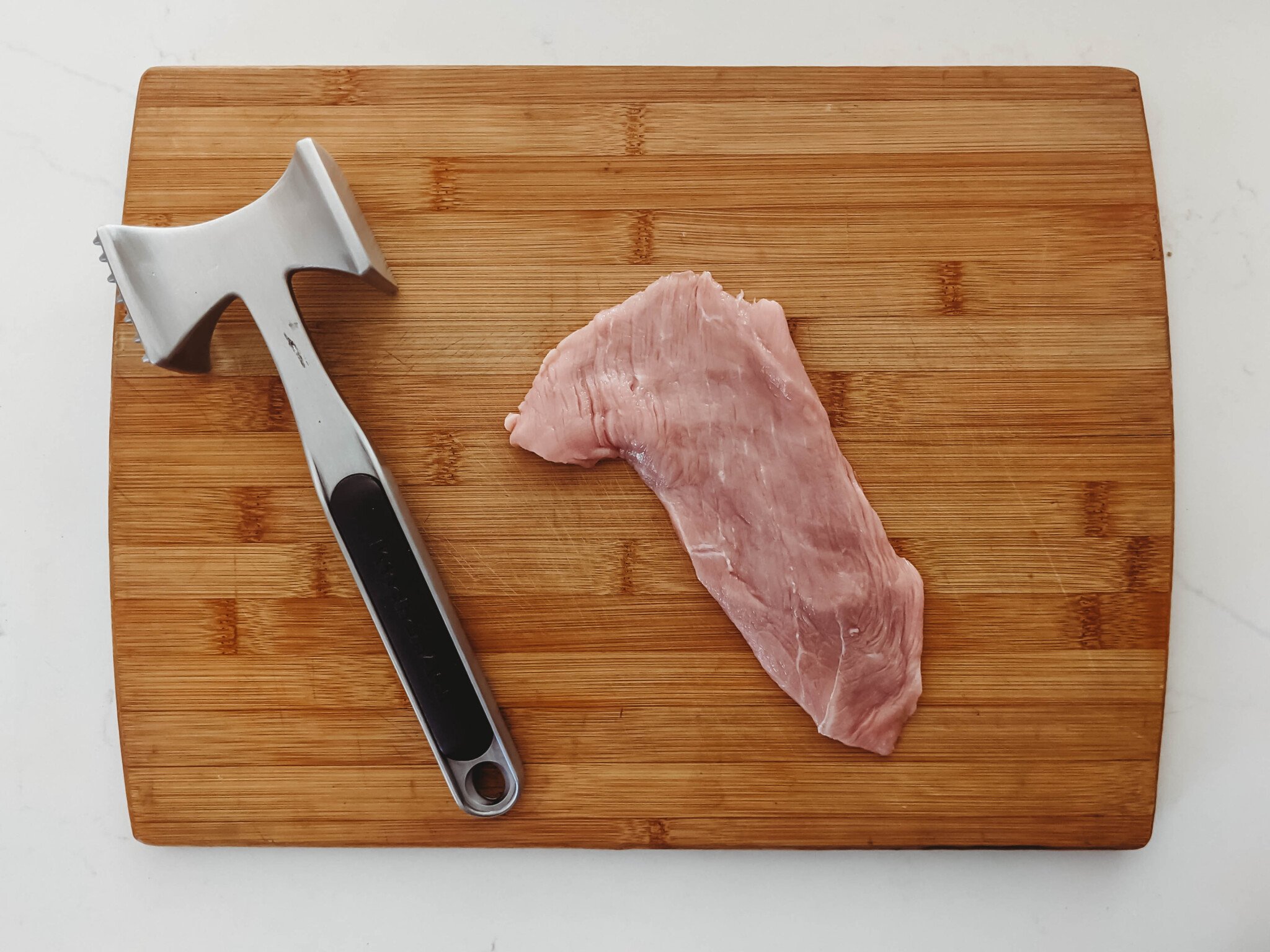 veal cutlet on a cutting board pounded thin