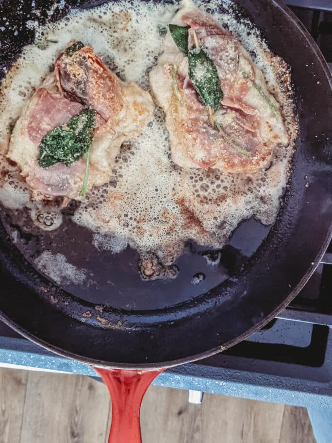 veal saltimbocca being fried in a skillet 