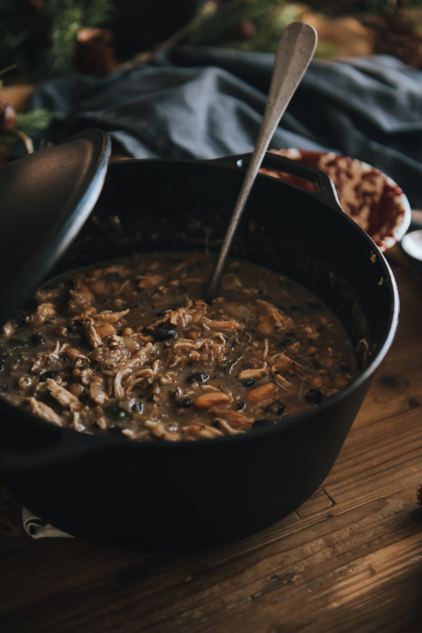 Dutch oven with shredded chicken returned to pot for white chicken chili recipe.