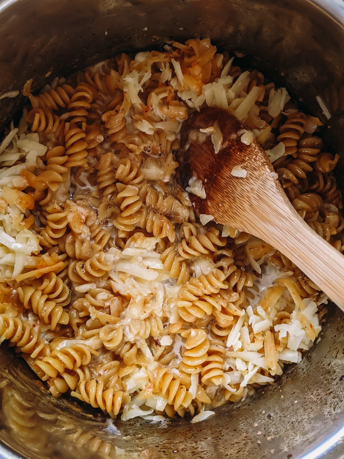 stirring cheese until melted into cooked pasta for macaroni and cheese