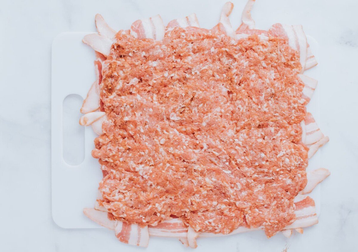 adding ground sausage on top of folded bacon strips