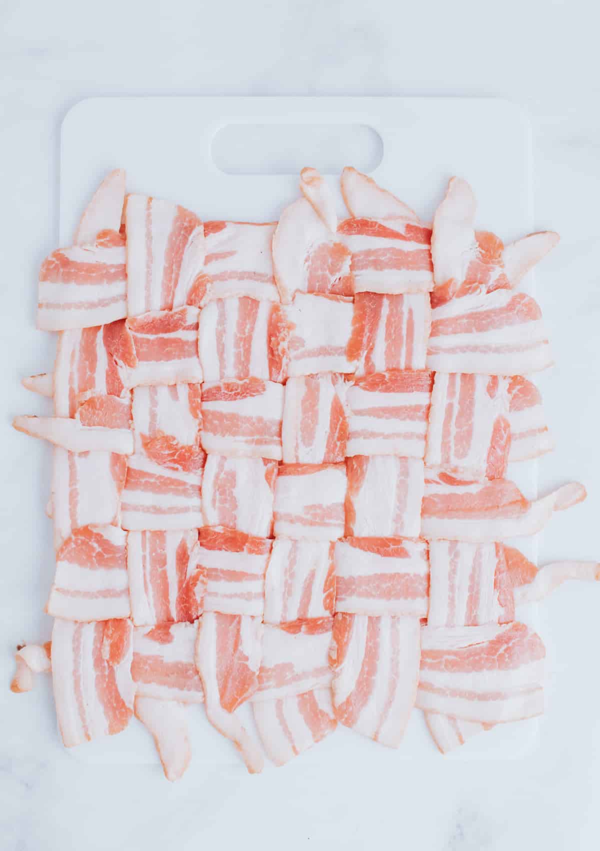 folding strips of bacon on a cutting board