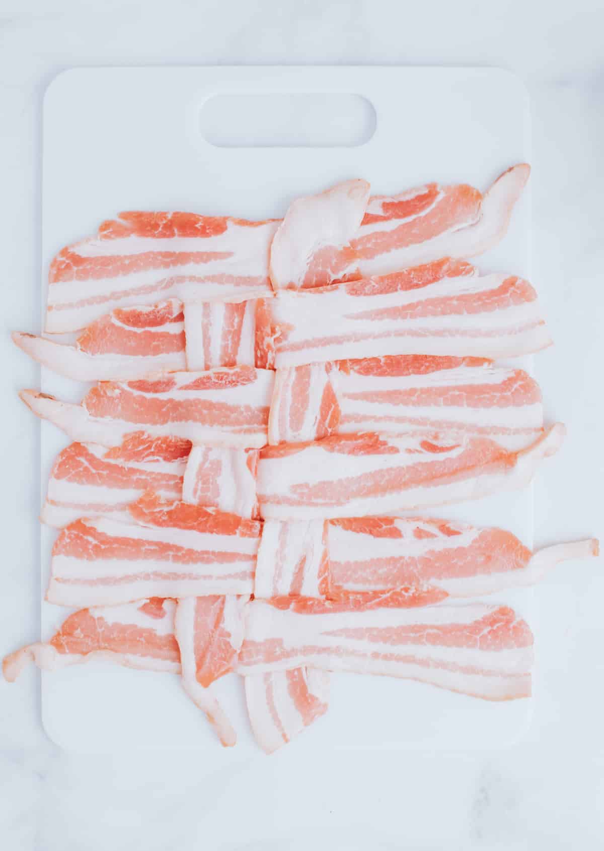 folding strips of bacon on a cutting board