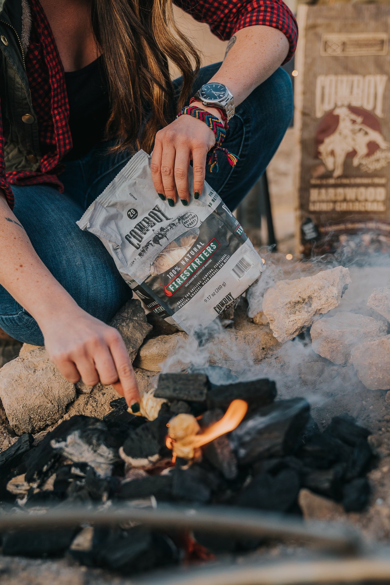 Firestarters being placed into charcoal to ignite it. 