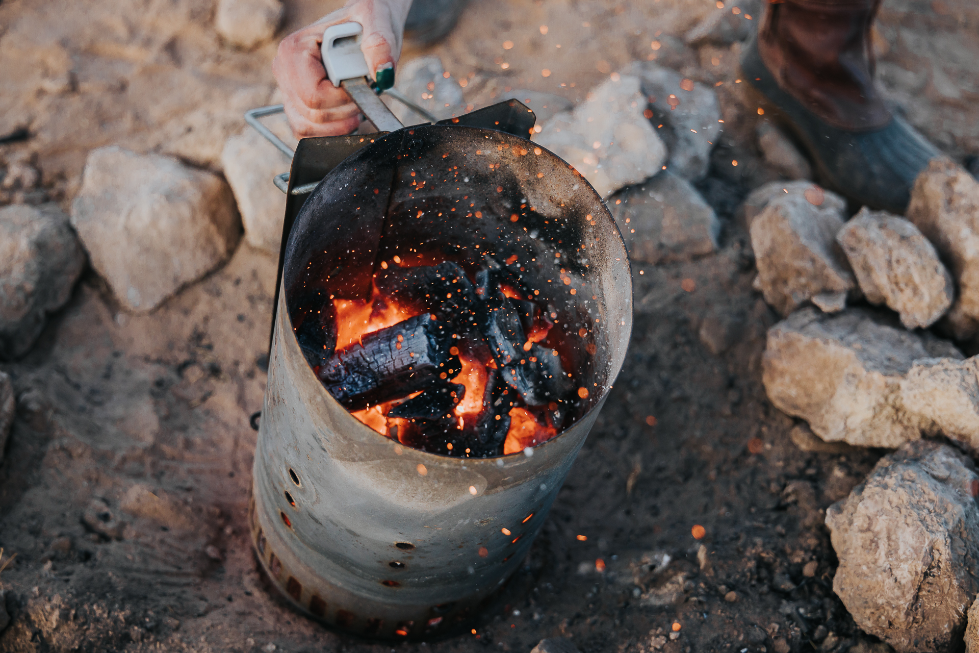 Charcoal in a charcoal chimney glowing and ready to be poured into a grill