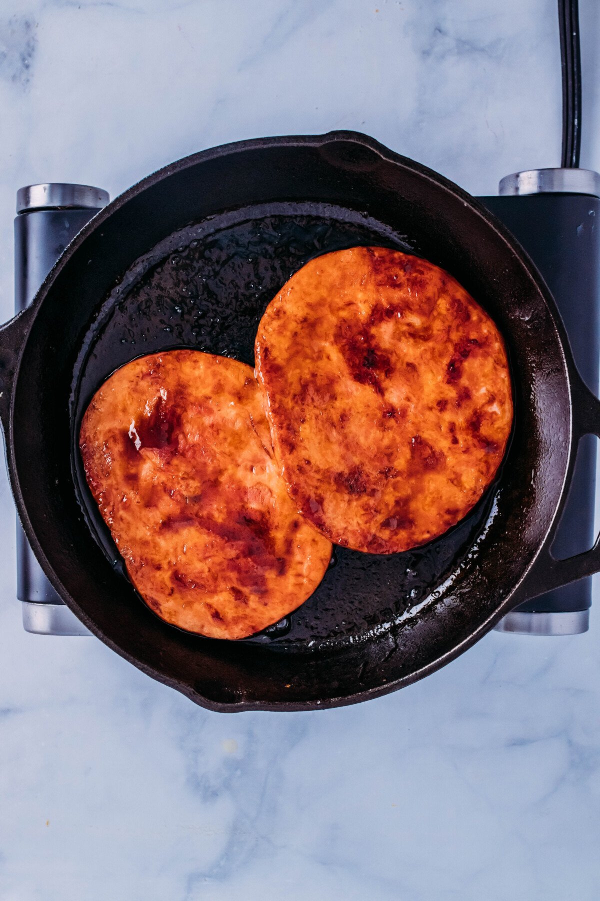 ham steaks in cola sauce in cast iron pan