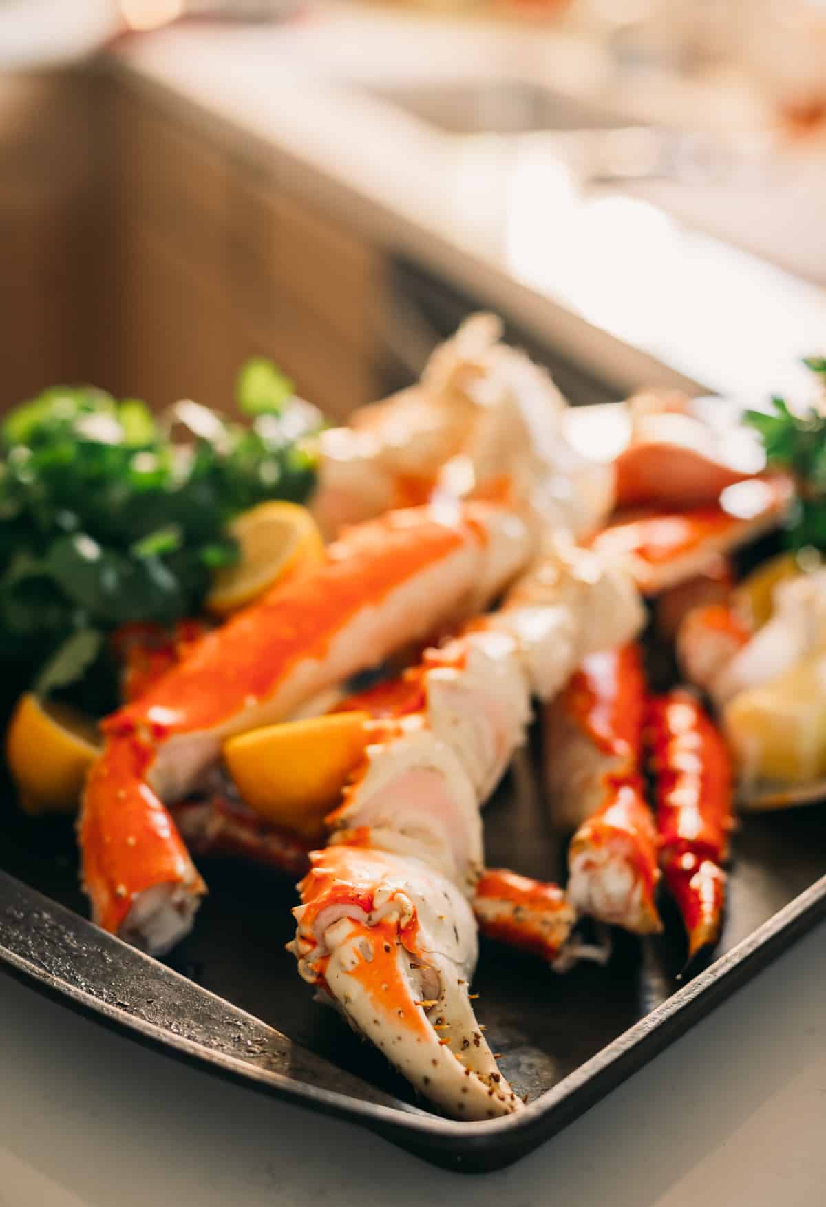 Pile of king crab on a black tray.