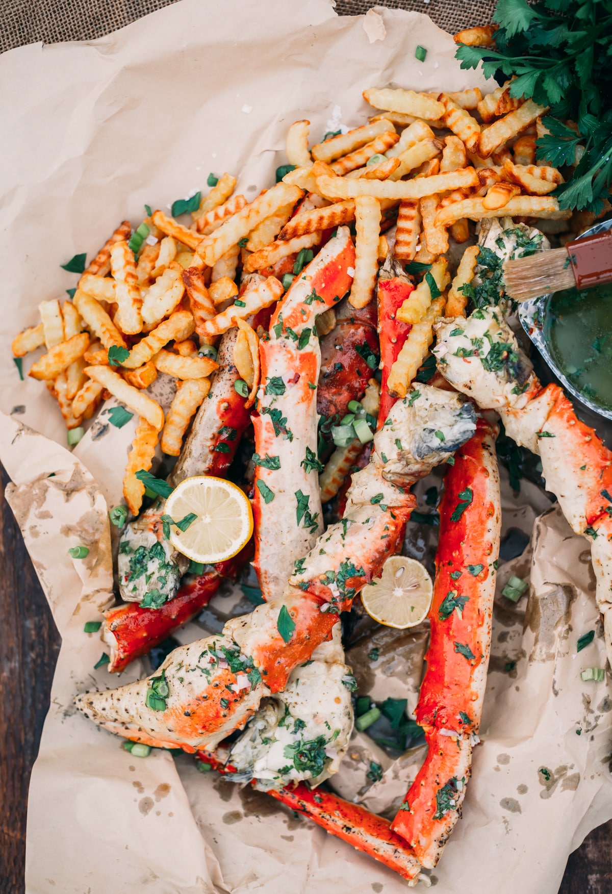 Platter of butter basted king crab, lemons and fries.