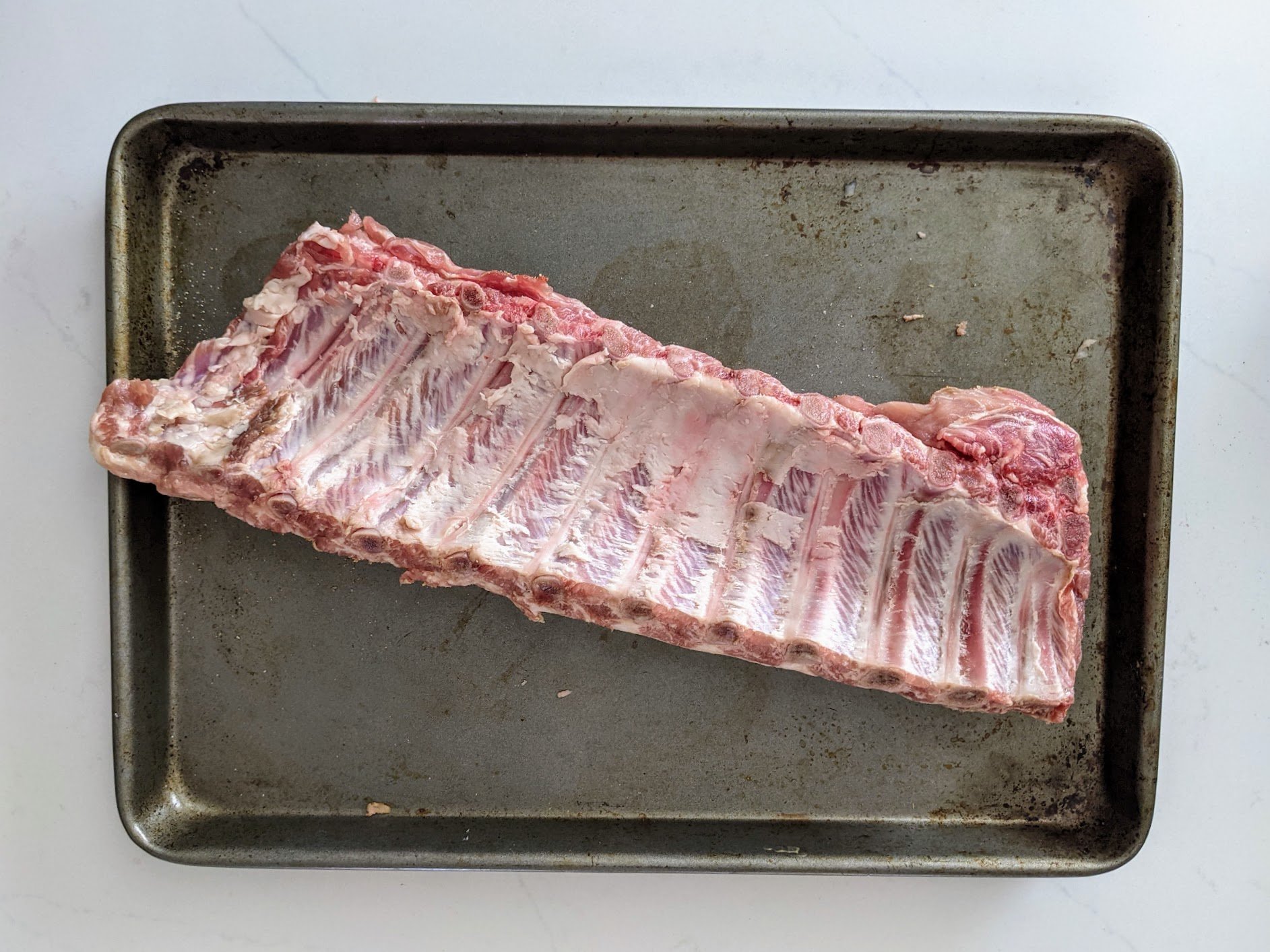rack of ribs showing the back where the bones are with the membrane removed 