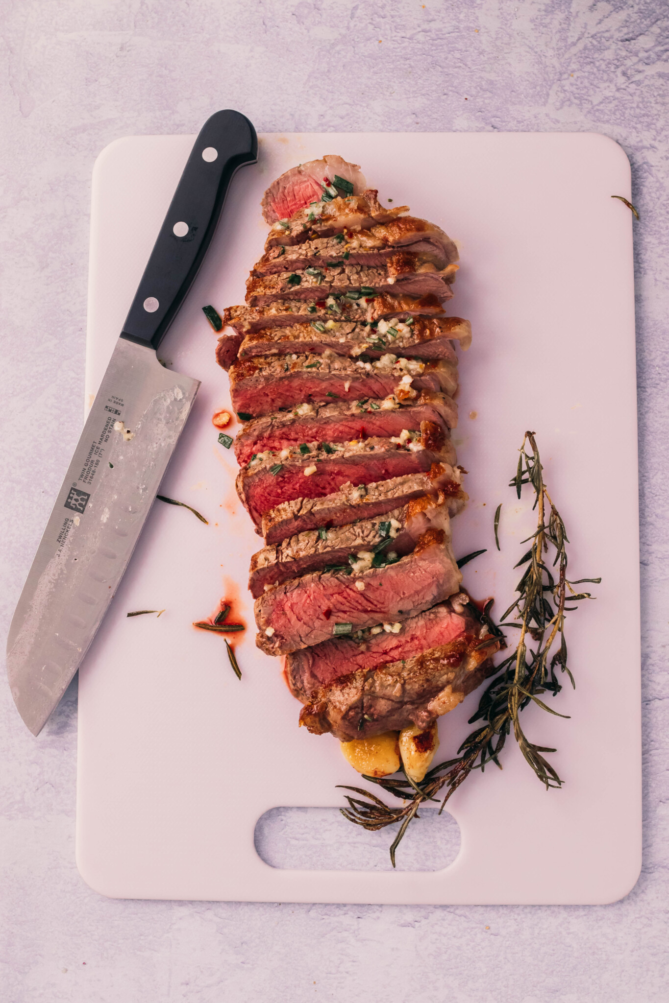 Sliced strip steak on cutting board. 