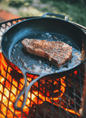 steak in cast iron over fire