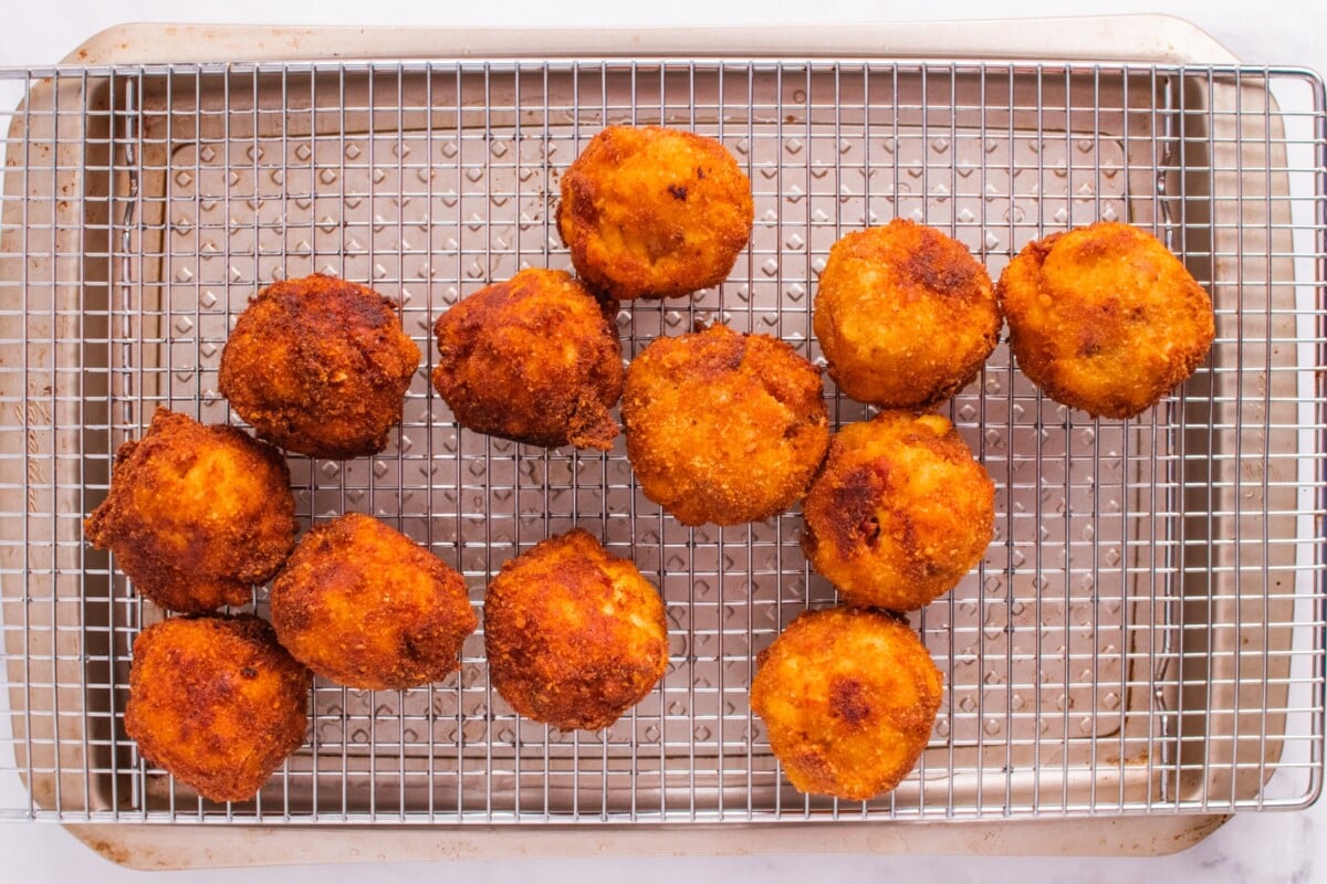 macaroni balls fried and drying on a baking rack