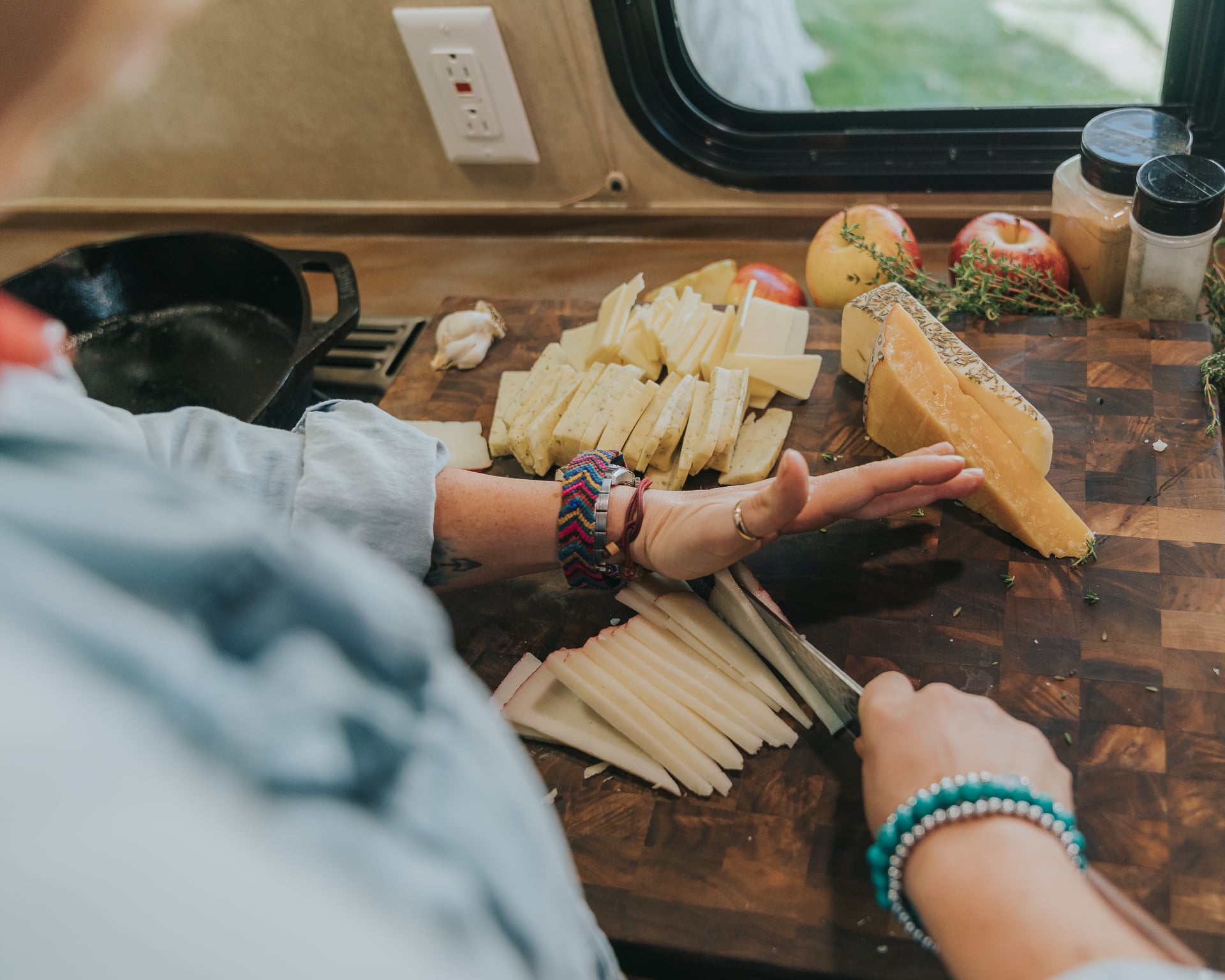 Hands holding knife to slice cheese.