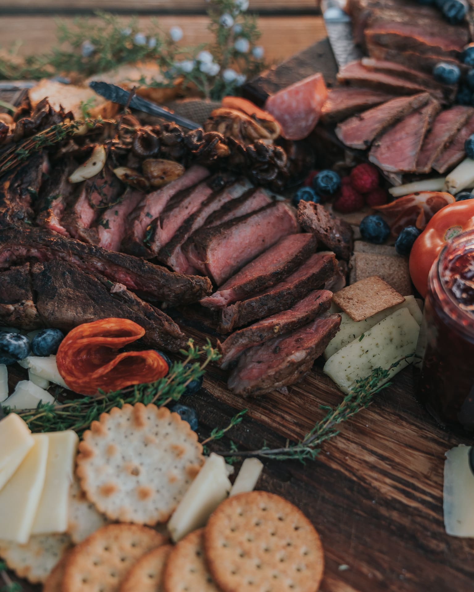 Cooked steaks sliced for serving on a charcuterie board. 