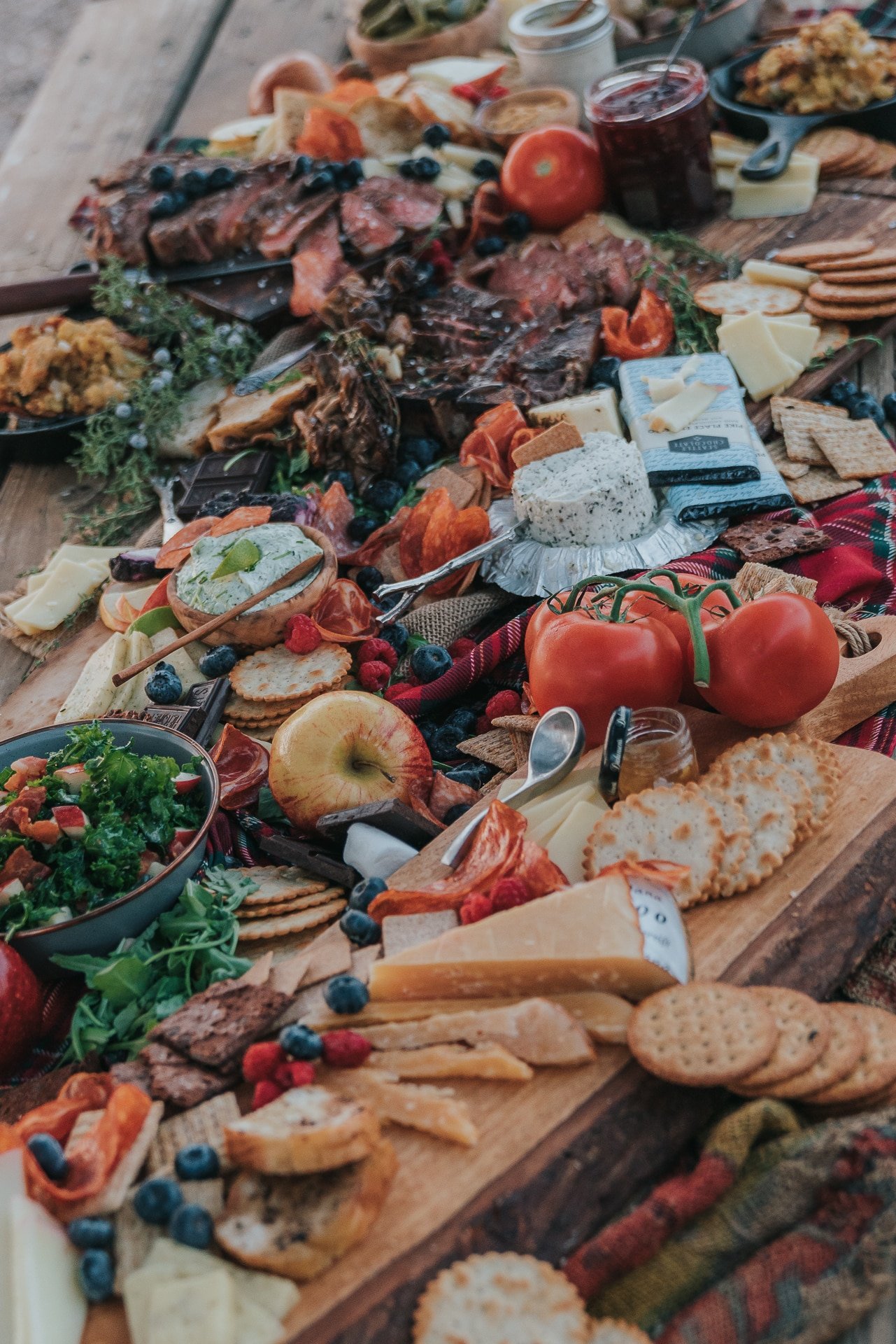 Abundant table filled with crackers, meats, cheeses, and more.