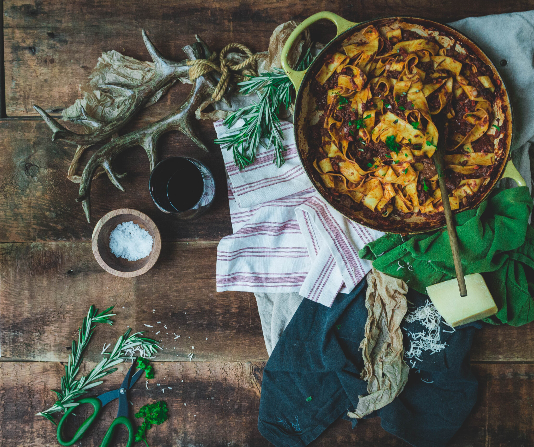 Overhead of beef cheek ragu braised and shredded, tossed with pasta and ready to be served from a large braiser