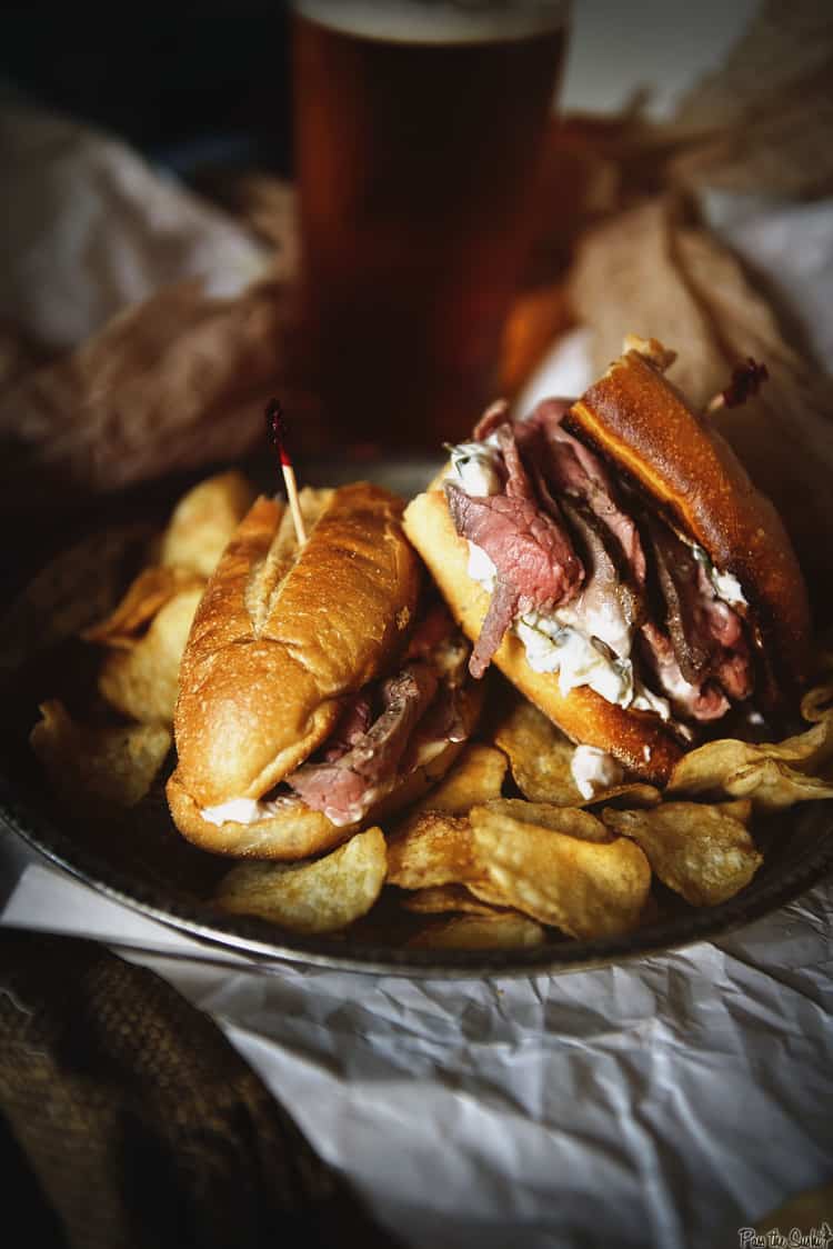 Close up of a mouthwatering French Dip sandwich on a rustic table. 