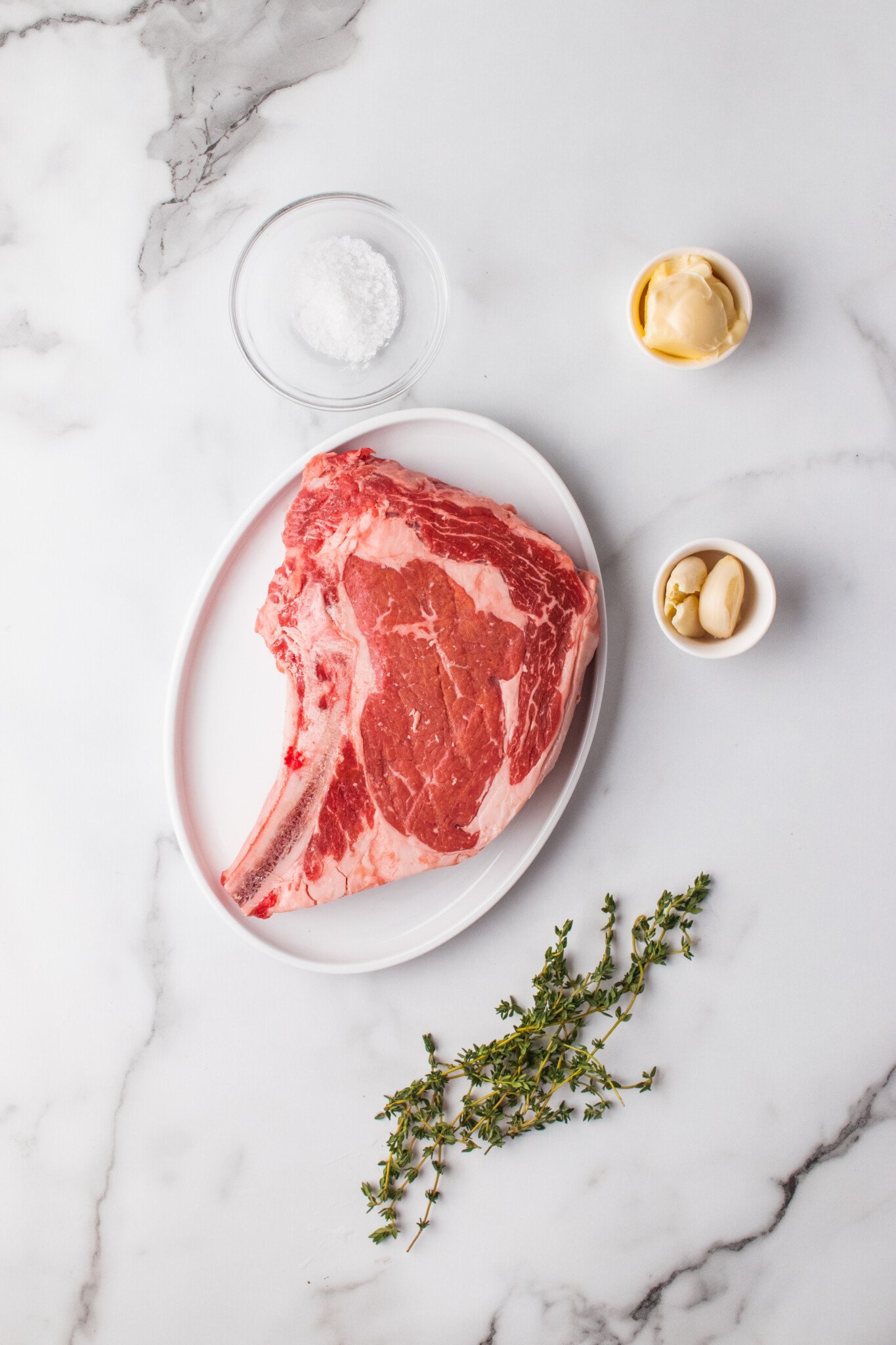 Ribeye steak on the counter with other ingredients. 