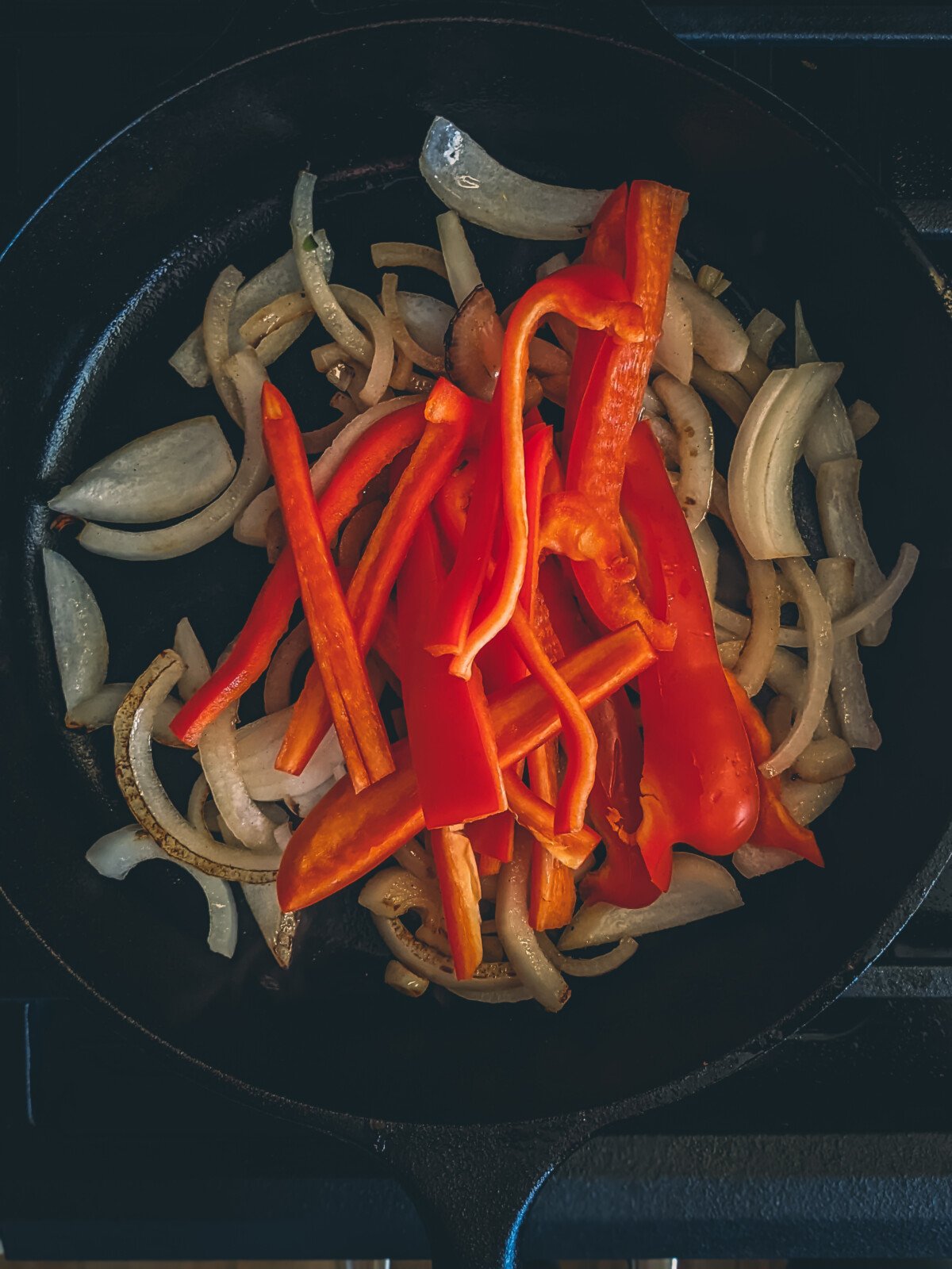 Onions and peppers in a cast iron skillet. 
