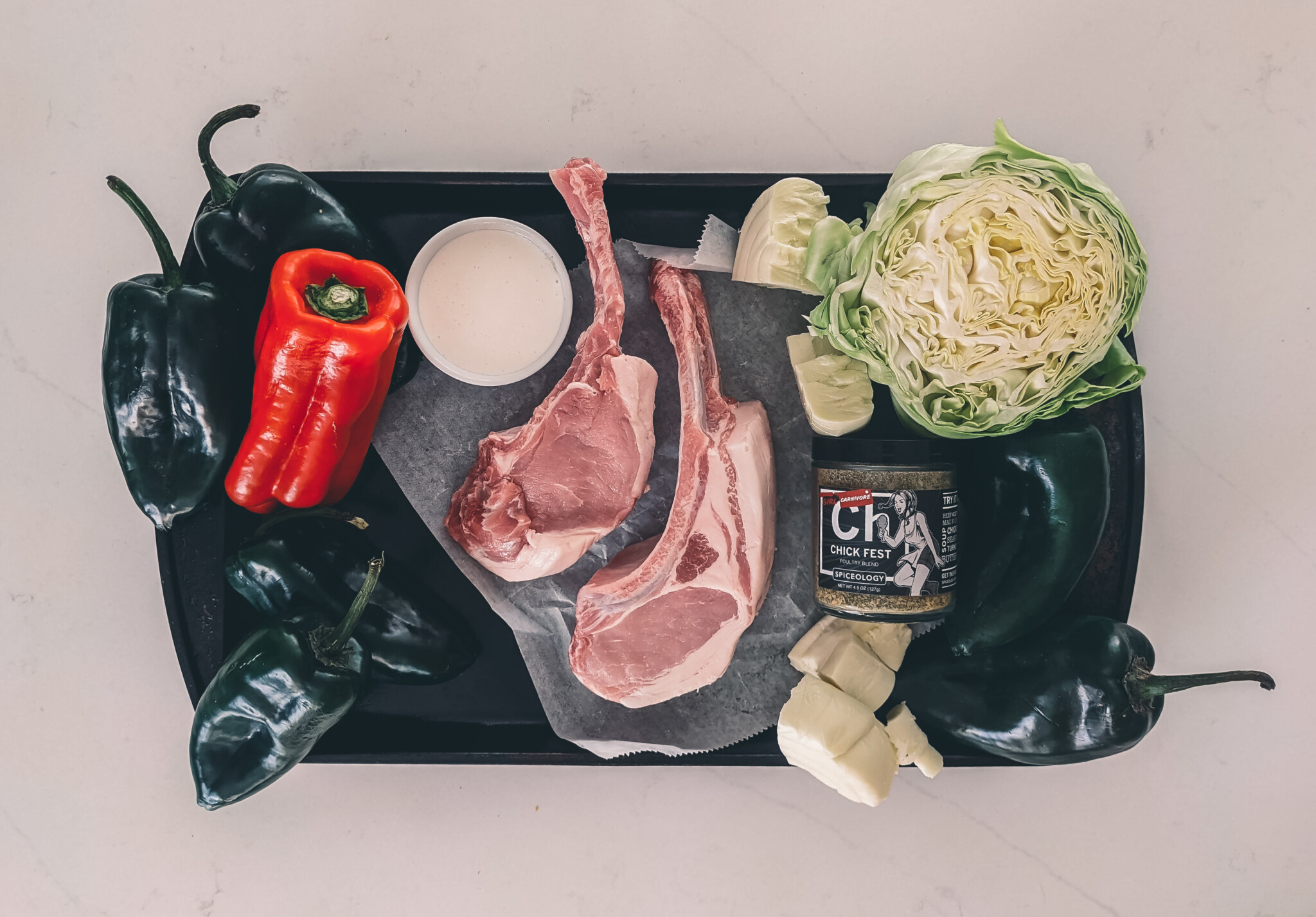 Ingredients for pan seared pork chops. 2 Double cut thick pork chops with salt, and spices along with components for side dishes 