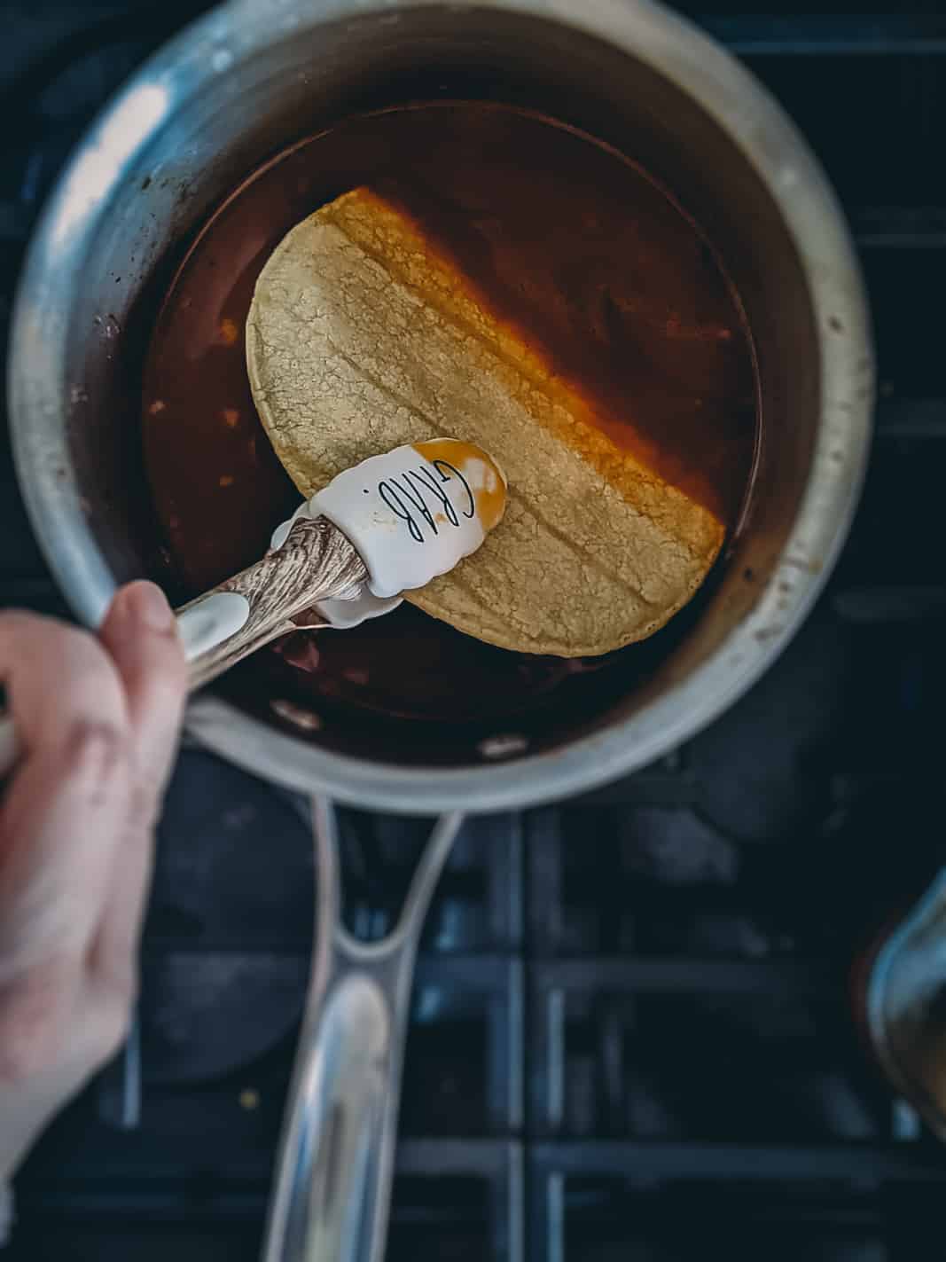 Dipping tortillas in birria broth. 