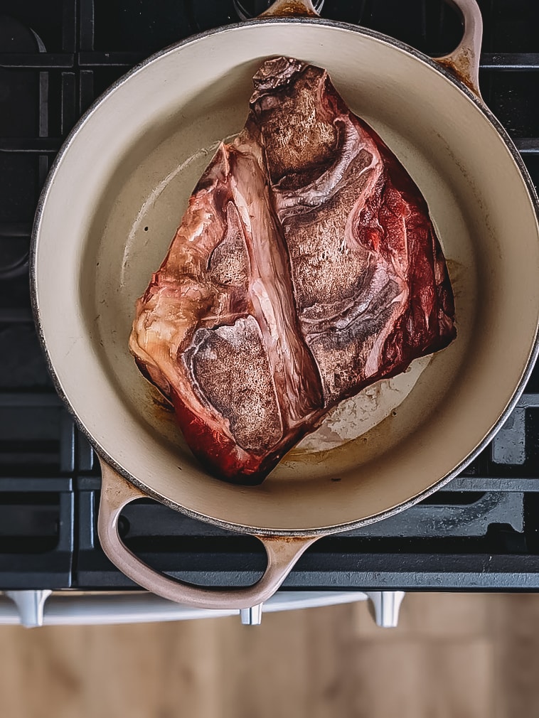 Beef neck in a dutch oven being seared. 