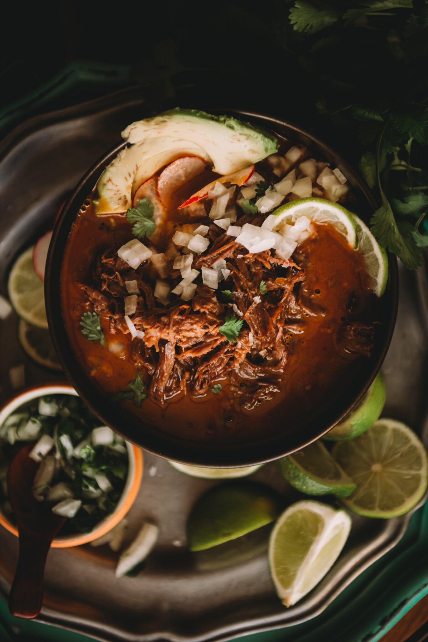 Close up of the birria to show shredded beef neck swimming in flavorful broth.