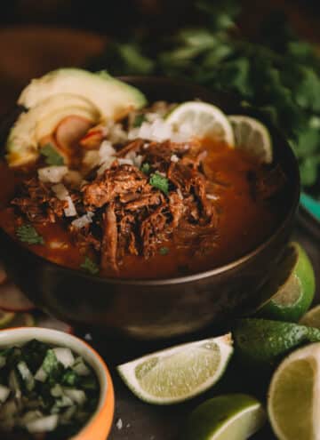 Close up shot of Mexican birria; shredded tender beef in a rich chilies infused broth