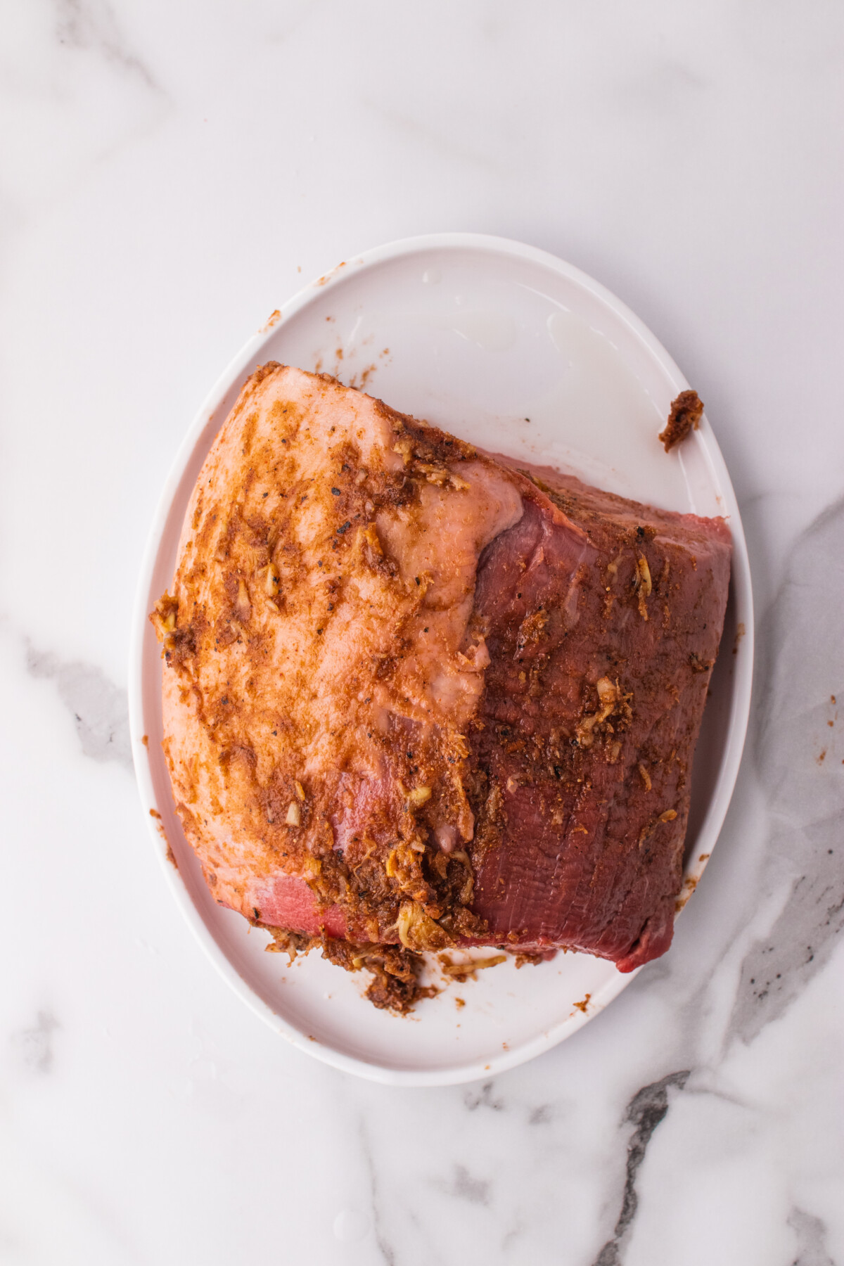 Raw eye of round roast rubbed with garlic spice mix.