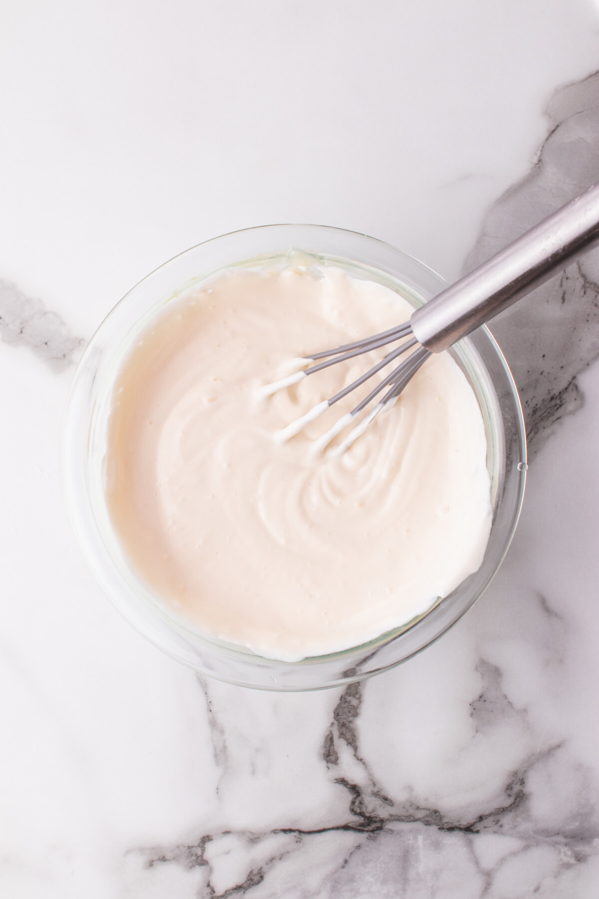 Mayo and sour cream whisked together in a bowl.