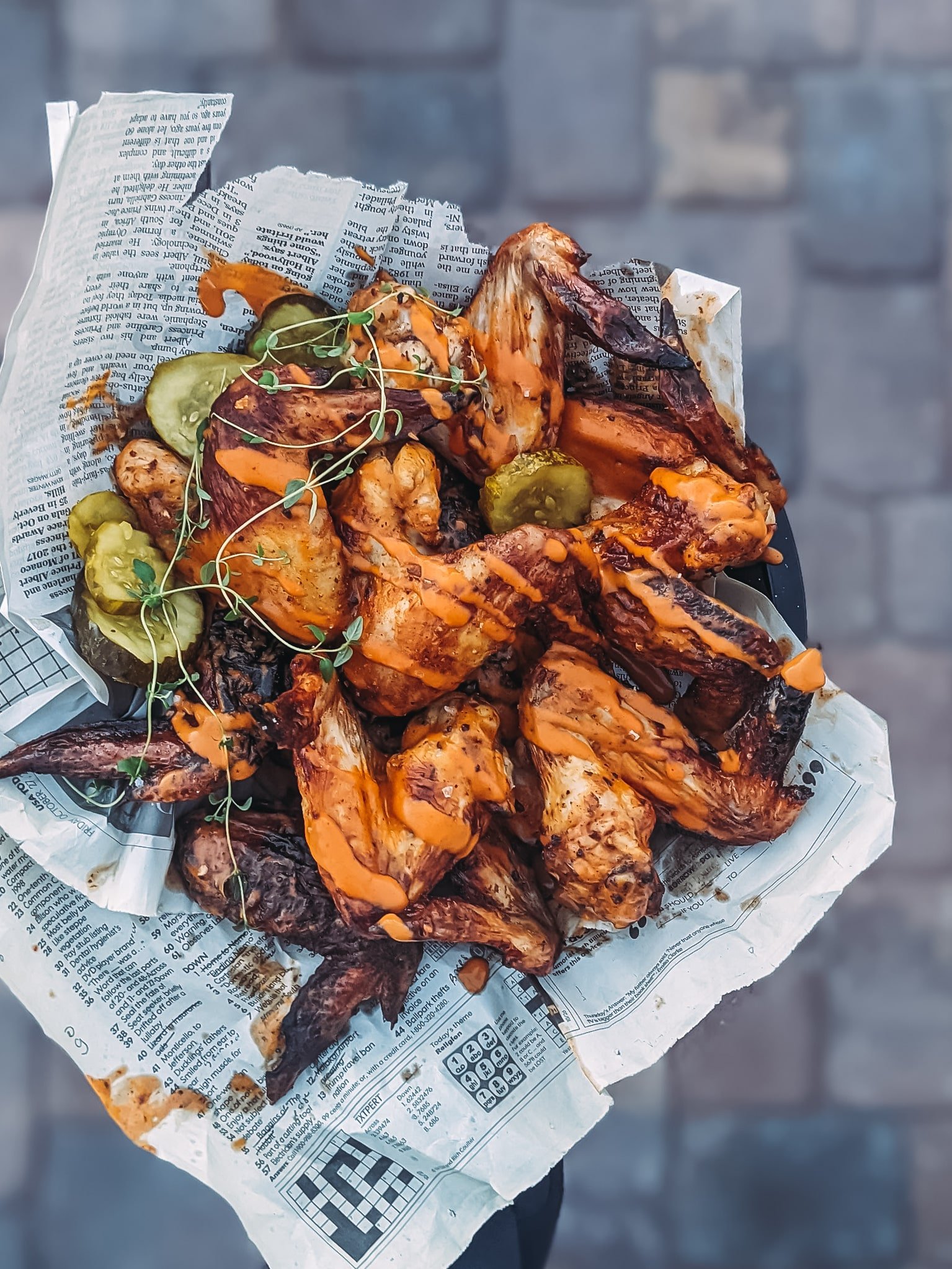 Plate of air fryer chicken wings drizzled with buffalo sauce and garnished with pickles - cuz they were pickle brined wings! 